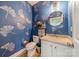 Charming powder room featuring blue walls with ginkgo leaf decals and a round mirror at 228 Red Dog Dr, Mooresville, NC 28115