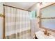 Neutral bathroom with tiled walls, framed mirror, single sink and shower curtain at 2614 Thornton Rd, Charlotte, NC 28208