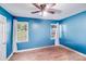 Bright blue bedroom with hardwood floors, windows, and white curtains offers a comfortable space at 2614 Thornton Rd, Charlotte, NC 28208
