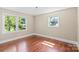 Bedroom with hardwood floors, two windows with backyard views, and light, neutral walls at 2721 Albany Ln, Charlotte, NC 28205