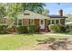 Charming brick home with a manicured lawn, complemented by lush green bushes at 2721 Albany Ln, Charlotte, NC 28205
