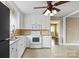 Kitchen with white appliances, white cabinets, tile floor, and a ceiling fan at 2721 Albany Ln, Charlotte, NC 28205