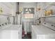 Laundry room equipped with modern washer and dryer units and ample shelving for storage at 2721 Albany Ln, Charlotte, NC 28205