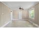 Bright living room with neutral walls, ceiling fan, and natural light streaming through the window at 2721 Albany Ln, Charlotte, NC 28205