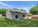 Back exterior of home with a grassy lawn, patio area, and mature trees at 3021 Dylan Nw Pl, Concord, NC 28027