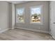 Bright bedroom with neutral walls, light wood-look flooring, large double windows, and white trim at 3804 Freedom Dr, Charlotte, NC 28208