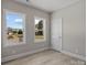Bedroom showcasing two large windows providing natural light, light wood-look flooring, and neutral walls at 3804 Freedom Dr, Charlotte, NC 28208