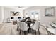 Modern dining area with round table, seating for six, and bright lighting, adjacent to backyard access and an airy living space at 3804 Freedom Dr, Charlotte, NC 28208