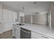 Modern kitchen featuring white cabinets, quartz countertops, stainless steel appliances and view to living room at 3804 Freedom Dr, Charlotte, NC 28208
