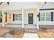 Welcoming front porch featuring brick accents, white columns, and black shutters, offering curb appeal at 417 Spring Sw St, Concord, NC 28025