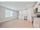 Bright kitchen with modern, stainless steel appliances, white cabinetry, and wood-look flooring at 417 Spring Sw St, Concord, NC 28025