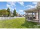 Expansive backyard featuring a white picket fence, a cozy screened porch, and a lush green lawn at 428 Whitewater Nw Way, Concord, NC 28027