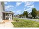 Spacious, grassy backyard with a patio, a fire pit, a white picket fence, and mature trees at 428 Whitewater Nw Way, Concord, NC 28027