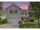 Charming two-story home features a well-maintained lawn, a two-car garage, and red window shutters at 428 Whitewater Nw Way, Concord, NC 28027