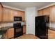 Well-equipped kitchen with wooden cabinets, black appliances, and granite counters for cooking convenience at 428 Whitewater Nw Way, Concord, NC 28027