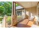 Cozy front porch with wooden floors, stone pillars, and a relaxing porch swing at 4925 Pageland Hwy, Monroe, NC 28112