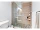 The bathroom features a walk-in shower with sleek glass doors, stone flooring, and a convenient built-in shelf at 4925 Pageland Hwy, Monroe, NC 28112