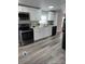 Modern kitchen with stainless steel appliances, white countertops, and gray wood-look floors at 5767 Swinging Bridge Rd, Conover, NC 28613