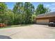 The backyard features an expansive driveway, a basketball hoop, a fire pit, and mature trees at 73 Wyth Sw Ct, Concord, NC 28025