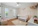 Cozy bedroom featuring neutral walls, hardwood floors, new windows, and a comfortable crib at 73 Wyth Sw Ct, Concord, NC 28025