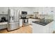 Bright kitchen with white cabinets, stainless steel appliances, black countertops, and wood flooring at 73 Wyth Sw Ct, Concord, NC 28025