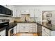 Modern kitchen features granite countertops, stainless appliances, white cabinets, and tile backsplash at 73 Wyth Sw Ct, Concord, NC 28025