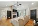 Cozy living room with whitewashed brick fireplace, wood floors, vaulted ceiling, and natural light at 73 Wyth Sw Ct, Concord, NC 28025