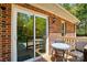 Charming outdoor patio featuring sliding glass doors, brick exterior, and cozy patio furniture at 73 Wyth Sw Ct, Concord, NC 28025