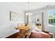 Light-filled dining area featuring wood table, bench seating, modern chandelier and sliding glass doors at 8504 Sunset Hill Rd, Waxhaw, NC 28173
