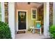 Inviting front porch with a welcoming wreath on the door and rocking chair at 8504 Sunset Hill Rd, Waxhaw, NC 28173
