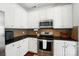 Well-equipped kitchen featuring white cabinetry, stainless steel appliances, and dark countertops at 8504 Sunset Hill Rd, Waxhaw, NC 28173