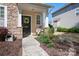 Cozy front porch with decorative floral wreath and potted plants with stone and siding exterior at 8524 Sunset Hill Rd, Waxhaw, NC 28173