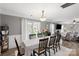 Elegant dining room with stylish lighting, seating for six, and views to the backyard and living room at 8604 Cedardale Ridge Ct, Charlotte, NC 28269