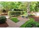 Lush backyard with manicured hedges, a brick patio, and a cozy seating area at 8934 Winged Bourne Dr, Charlotte, NC 28210