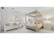 Bright bedroom with light walls, four poster bed, large windows, and a seating area at 8934 Winged Bourne Dr, Charlotte, NC 28210