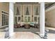 Covered patio with comfortable seating, stone flooring, and elegant columns at 8934 Winged Bourne Dr, Charlotte, NC 28210