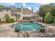 Beautiful pool with stone surround, manicured landscaping, and architectural details at 8934 Winged Bourne Dr, Charlotte, NC 28210