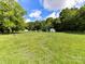 A view of the sprawling backyard with outbuildings, firepit, and surrounding nature at 915 Gate Rd, Monroe, NC 28112