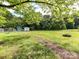 Expansive backyard featuring lush greenery, outbuildings, and a cozy fire pit at 915 Gate Rd, Monroe, NC 28112