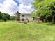 Backyard with a wooden deck and stone fire pit, surrounded by green lawns at 915 Gate Rd, Monroe, NC 28112