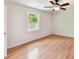 A cozy bedroom with hardwood floors, ceiling fan, and a window view of green trees at 915 Gate Rd, Monroe, NC 28112