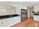 Bright kitchen features granite counters, white cabinets, stainless refrigerator, and pass-through to living space at 915 Gate Rd, Monroe, NC 28112