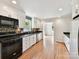 Well-lit kitchen with granite countertops, stainless dishwasher, dark appliances, and tiled backsplash at 915 Gate Rd, Monroe, NC 28112