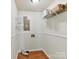 Functional laundry room with laminate floors and shelving for optimal organization and storage solutions at 915 Gate Rd, Monroe, NC 28112