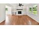 Inviting living room with hardwood floors, a cozy fireplace with built-in shelving, and bright windows at 915 Gate Rd, Monroe, NC 28112