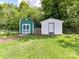 Two wooden outbuildings on a grassy lawn, surrounded by lush trees at 915 Gate Rd, Monroe, NC 28112
