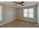 A well-lit bedroom featuring neutral paint, plush carpeting, a ceiling fan, and a large window at 932 3Rd Street Sw Pl, Hickory, NC 28602