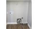 Bright laundry room with wooden floors, neutral paint, shelving, and hookups ready for washer and dryer at 932 3Rd Street Sw Pl, Hickory, NC 28602