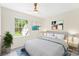 A bright bedroom features tasteful art, a large window, a ceiling fan, and soft gray carpet flooring at 103 Colonel Richard Rankin Dr, Stanley, NC 28164