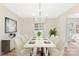 Bright dining room with a large rectangular table, modern chandelier, and a serving buffet at 103 Colonel Richard Rankin Dr, Stanley, NC 28164